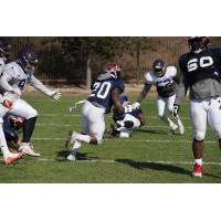 Zac Stacy of the Memphis Express runs through the Atlanta Legends during a joint practice