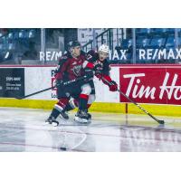 Vancouver Giants centre Justin Sourdif (left) vs. the Prince George Cougars