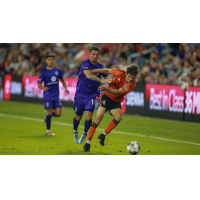 Louisville City FC midfielder Niall McCabe (center) fights for the ball