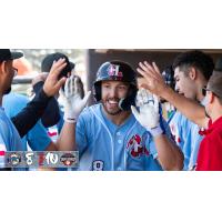 Tucker Mitchell receives congratulations in the Hickory Crawdads dugout