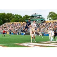 Rhode Island FC and Louisville City FC battle for a ball in the air