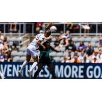 Racing Louisville FC defender Abby Erceg goes high for a ball