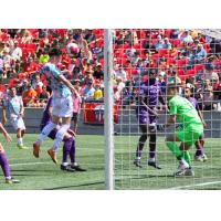 Sam Salter of Atlético Ottawa with a header against Pacific FC