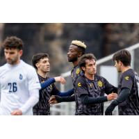 Pittsburgh Riverhounds exchange congratulations after scoring against Duquesne University